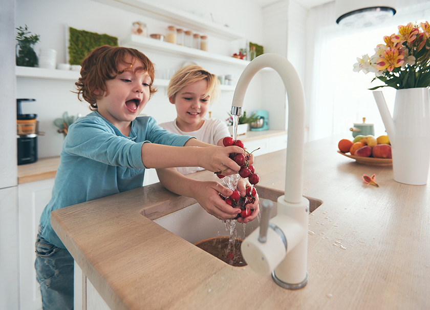 kids washing fruit in a remodeled kitchen